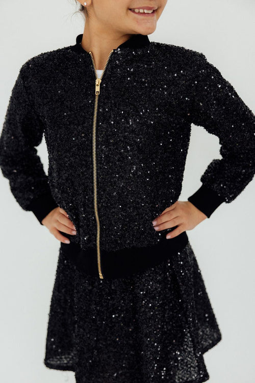 Close-up of the Mila & Rose black sequin bomber jacket worn over a matching black sequin skirt.