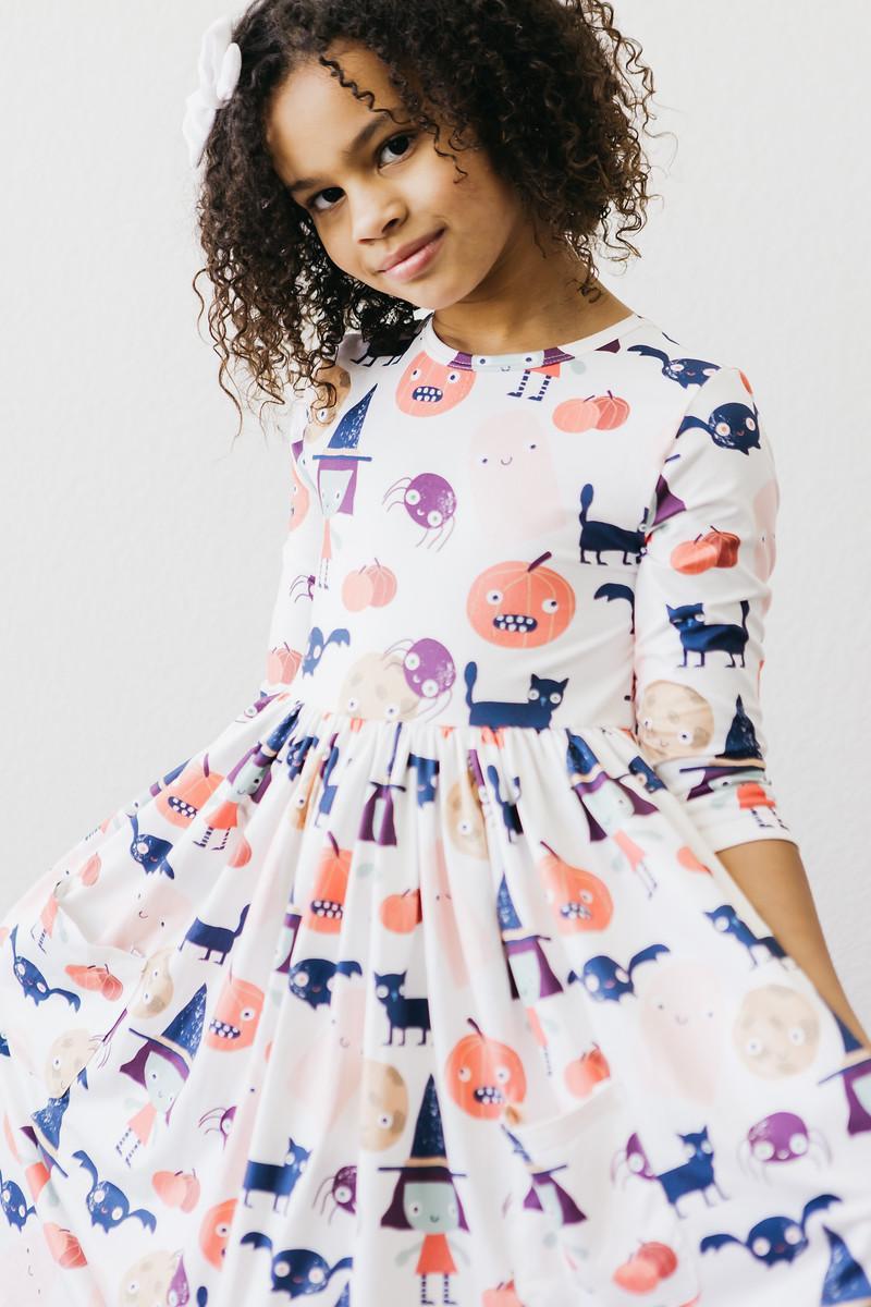 Girl spinning so the skirt of the Boo Crew twirl dress fans out.