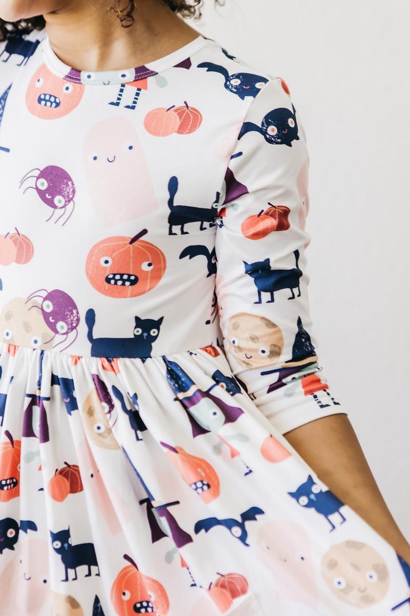 Close-up of the jack-o'-lantern, ghost, cat and bat print on the Boo Crew twirl dress.