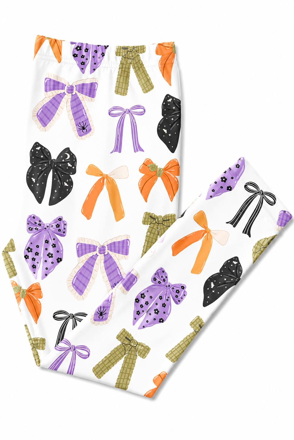 Flat lay of the Tied with a Boo leggings folded to show the printed bows in purple, orange, olive and black on white.