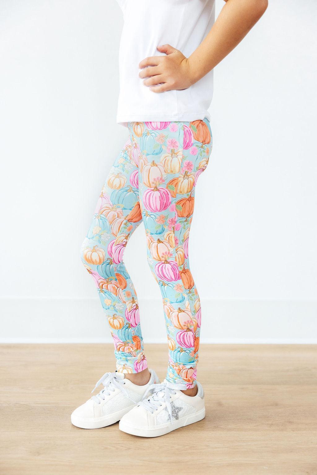 Girl photographed from the torso down wearing the Preppy Pumpkins leggings and white sneakers with a sparkle star detail.