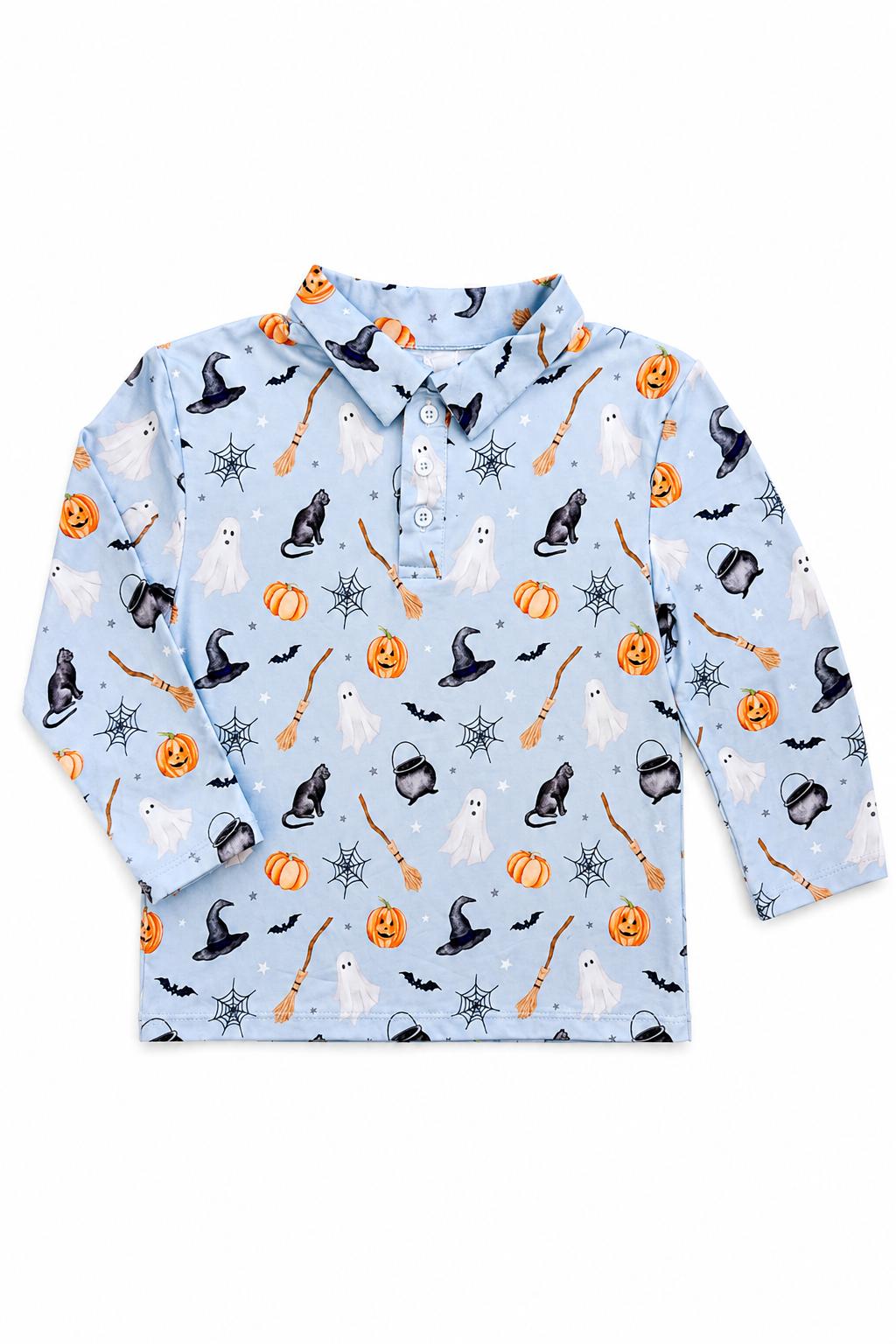 Flat lay of the Mila & Rose Spooky Season boys' long-sleeve polo, showing ghosts, black cats, witch hats, cauldrons, broomsticks, bats and jack-o'-lanterns on a light blue ground.